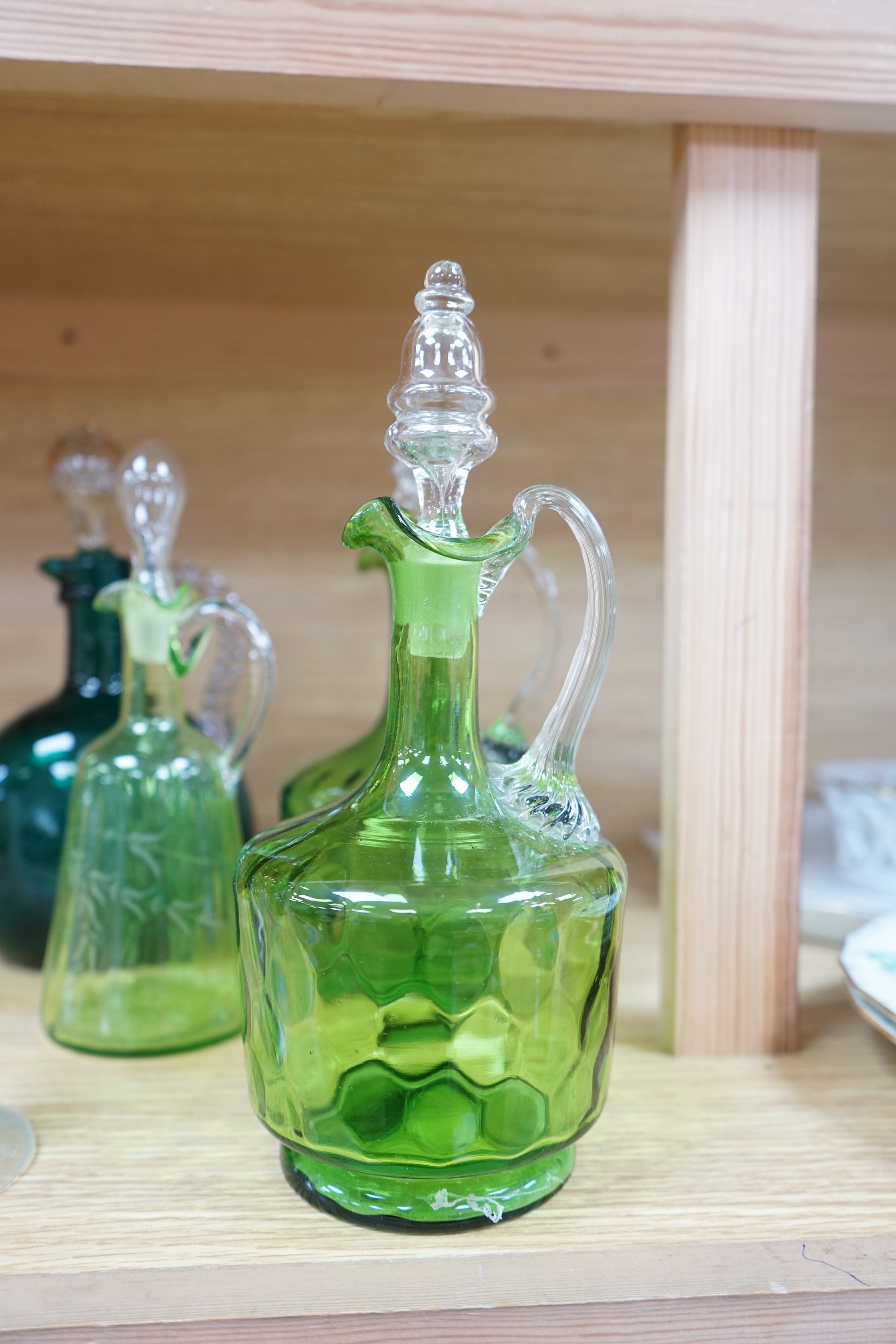 Ten glass items; a pair of green hock glasses, six liqueur decanters, a pedestal table centre and a mug. Condition - good.